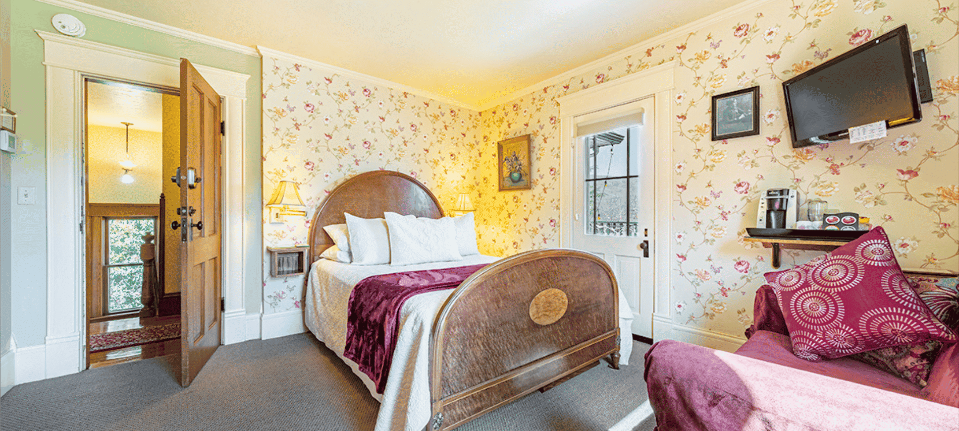 Queen guest room with floral wallpaper in pale green and pink with cream and maroon touches